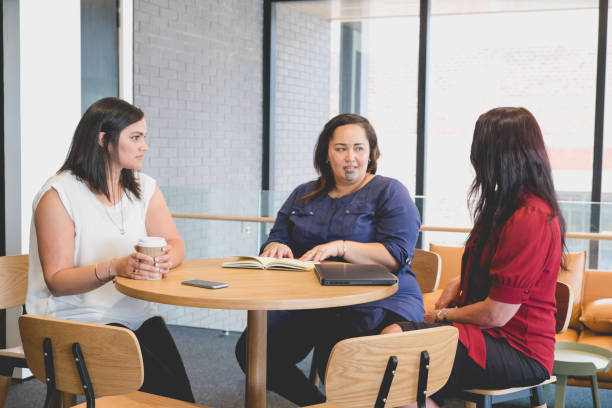 Three female business women in meeting. Diversity in work place with mixed caucasian and maori ethnicities, in Auckland, New Zealand, NZ